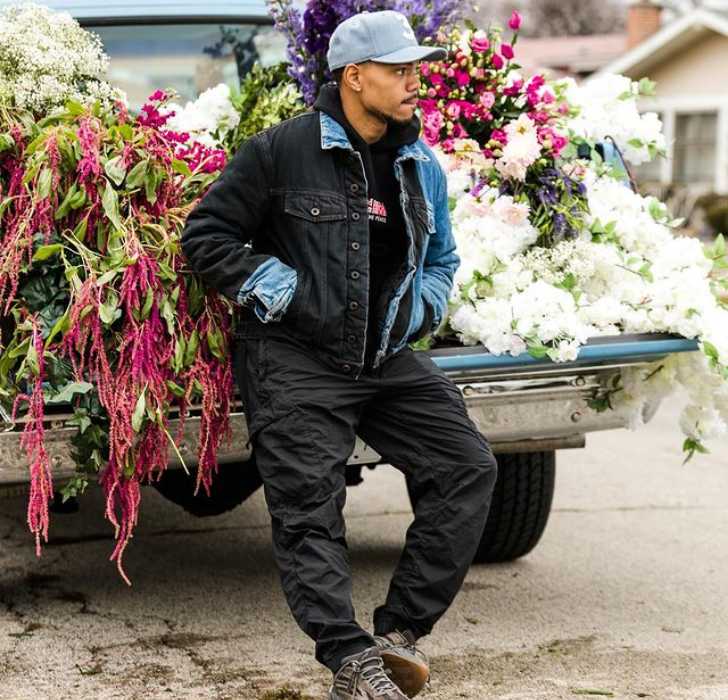 Picture of Chance The Rapper leaning on jeep full of jeep posing for a photo.